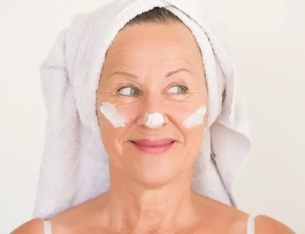 Mature woman with face cream for after summer skin treatment