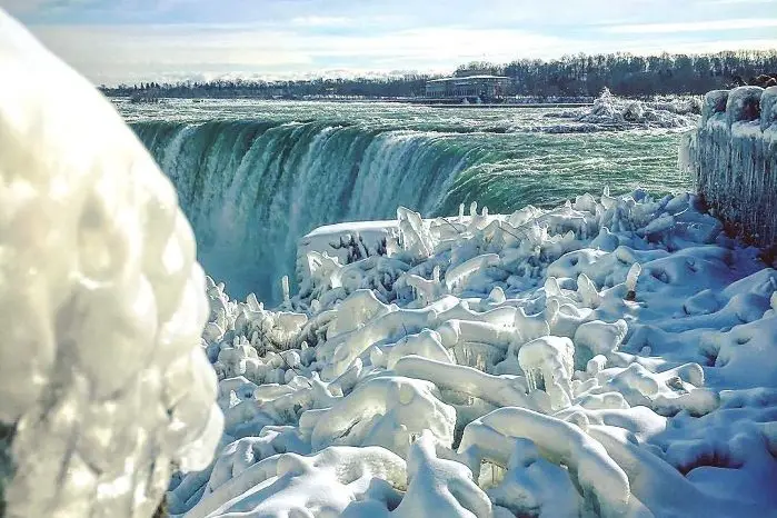 View of frozen ice formations at Niagara Falls in white, blue and green