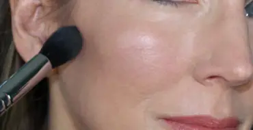 woman with brush on cheeks