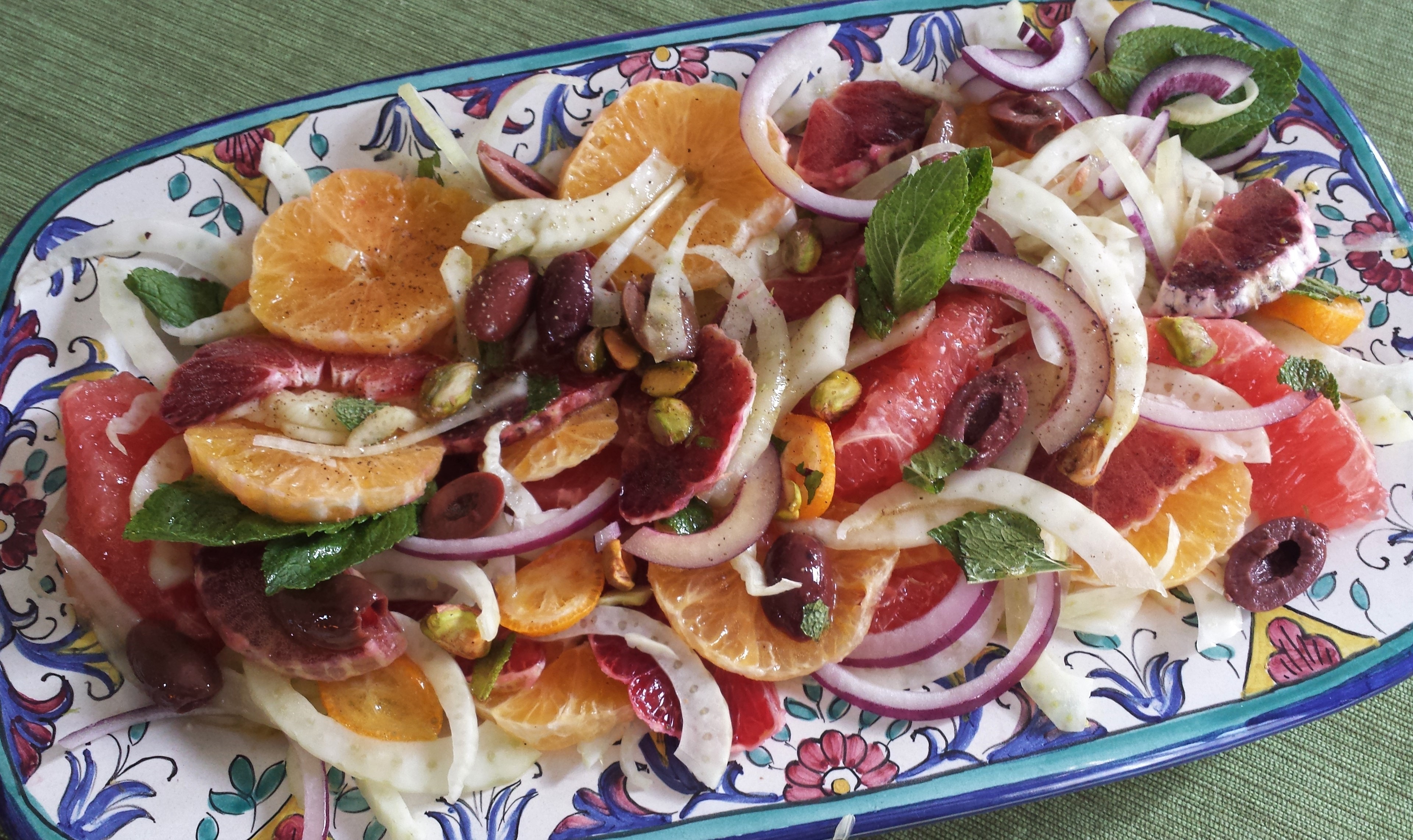 Colorful salad of citrus and fennel on blue patterned plate