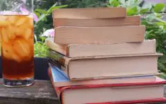 Stack of books with glass of iced tea
