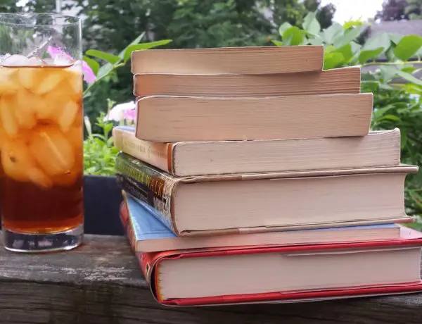 Stack of books with glass of iced tea