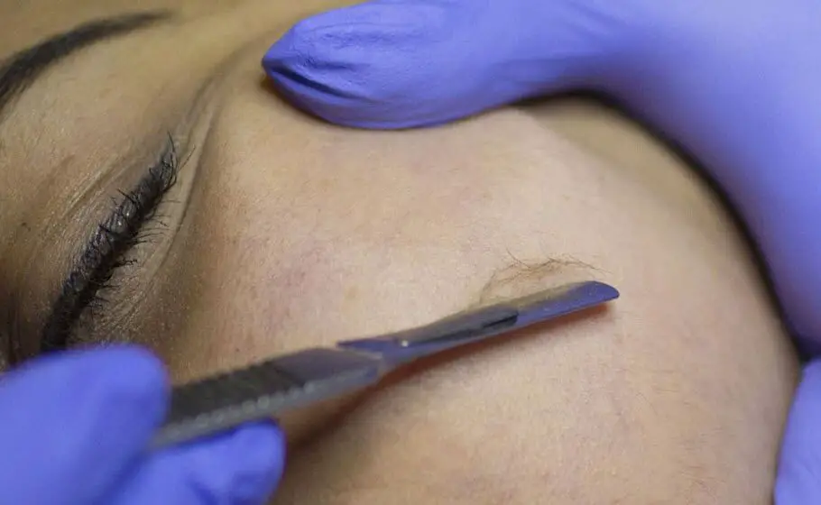 Woman's facial hair being shaved