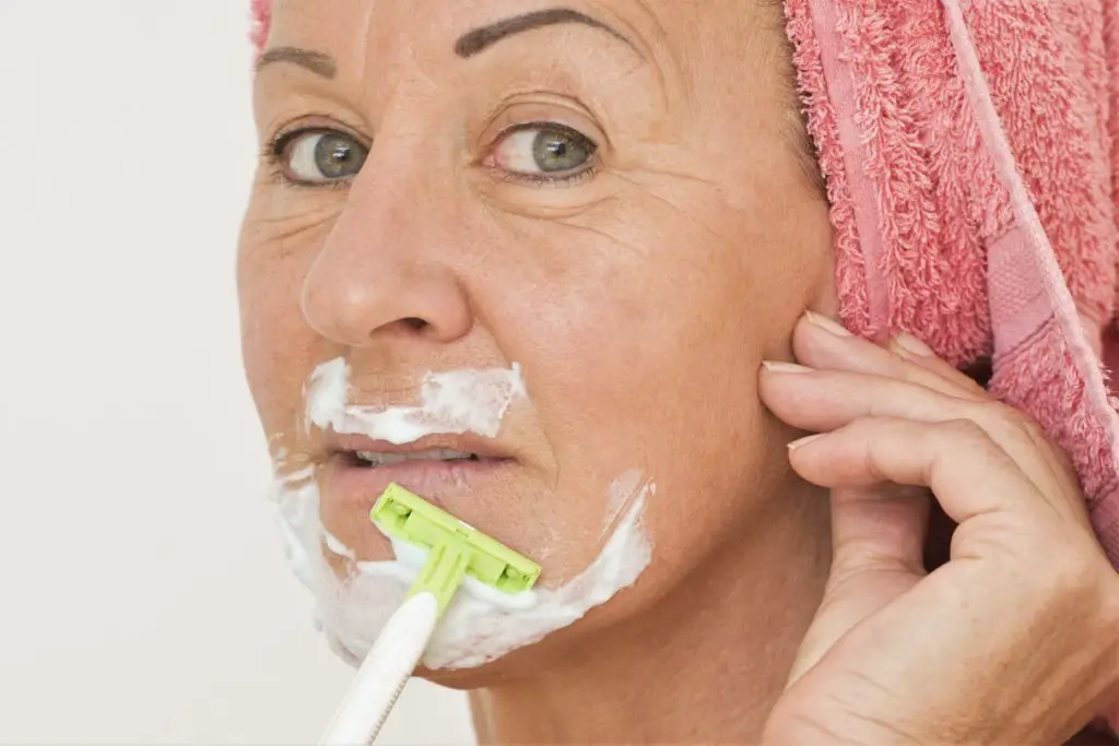 Woman shaving her face