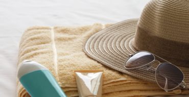 travel beauty products and straw hat