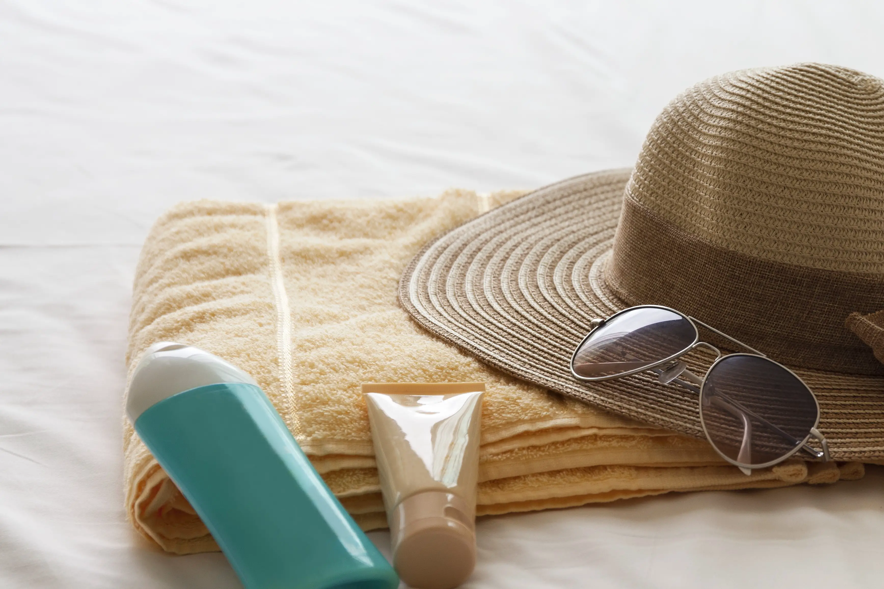 straw hat and lotions for travel