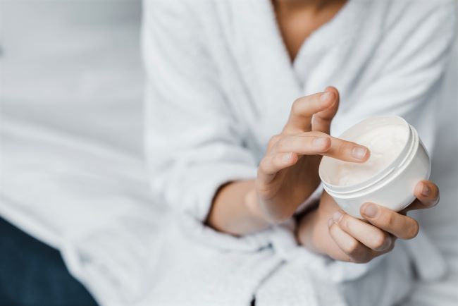 woman applying hand cream before bed