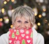 ^0 year old woman with Christmas gift