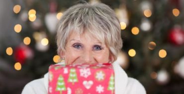 ^0 year old woman with Christmas gift