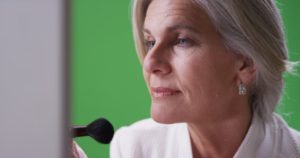 Woman applying blush makeup