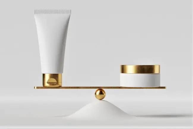 Two beauty products balancing evenly on a gold scale