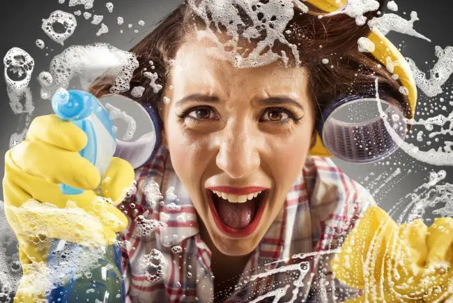 Flustered woman scrubbing kitchen