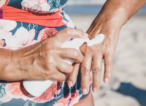 Woman over 60 applying sunscreen