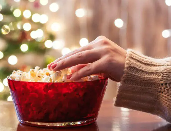 Woman reaching into popcorn bowl