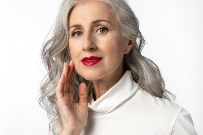 Beautiful mature woman with long gray hair wearing red lipstick