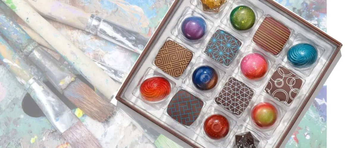 Box of gourmet chocolates with art in background