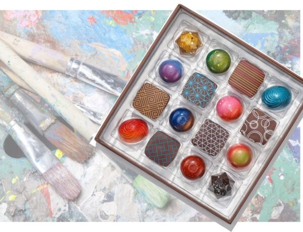 Box of gourmet chocolates with art in background