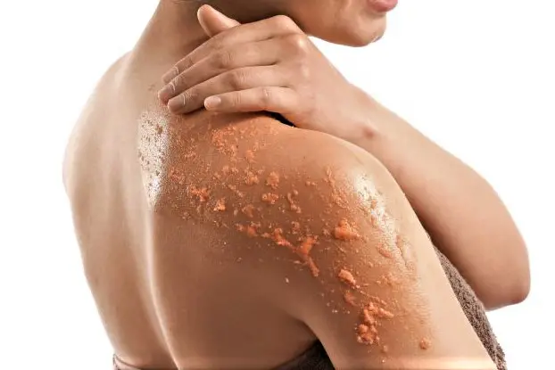 Woman exfoliates body