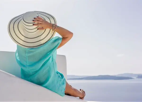 Woman overe 60 in turquoise beach cover up looking at sea