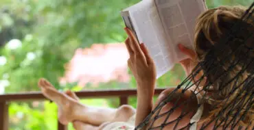 Woman over 60 in hammock reading book