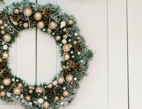 Christmas wreath with gold trim hanging on door