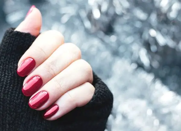 Woman's hand with shimmery red nails