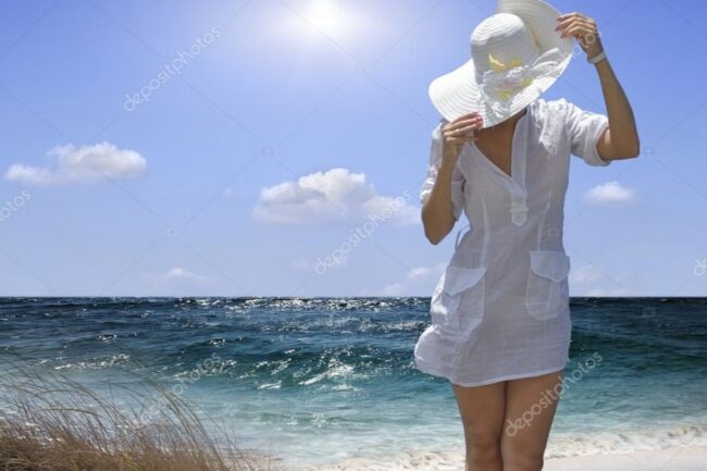 Woman wearing white beach cover u seascape