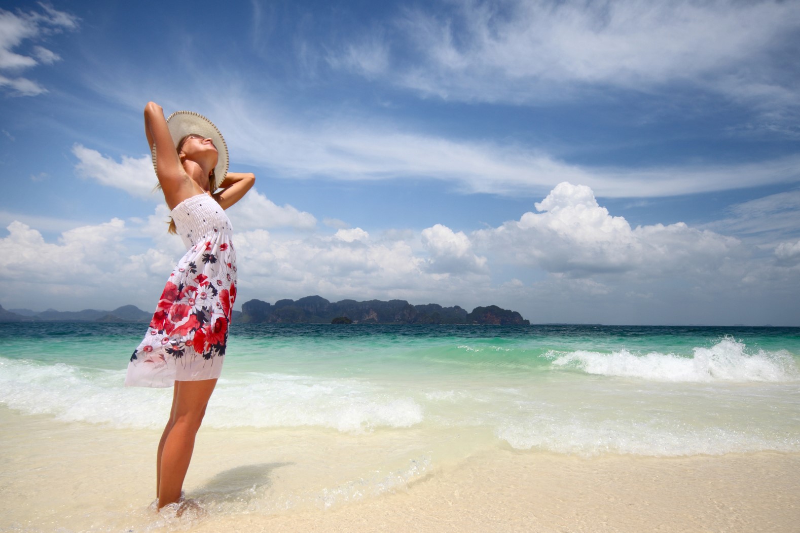 Woman standing on beach getting vitamin D from sun