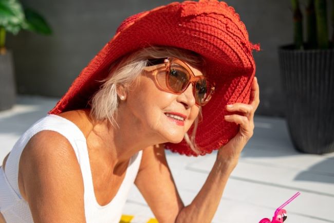 Senior woman in red hat end of summer
