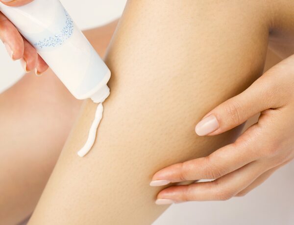 Woman applying lotion to legs for soft skin