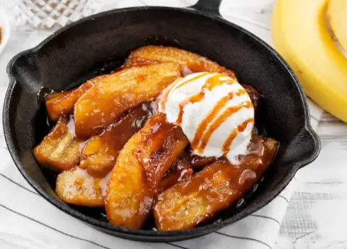 Bananas foster and vanilla ice cream in cast iron pan