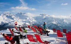 Skiers stting in chairs looking at mountains