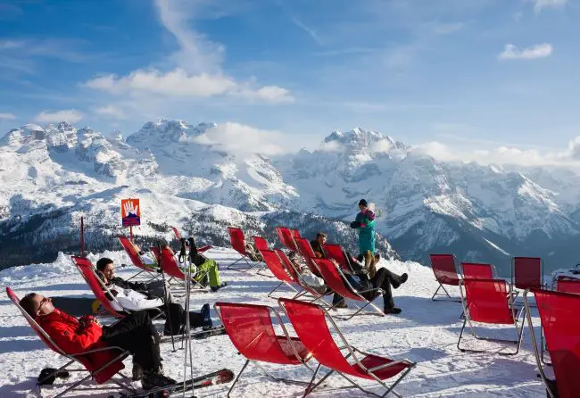 Skiers stting in chairs looking at mountains