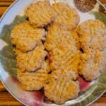 Plate with crispy cheese crackers on wood table
