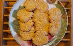 Plate with crispy cheese crackers on wood table
