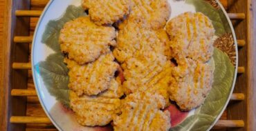 Plate with crispy cheese crackers on wood table